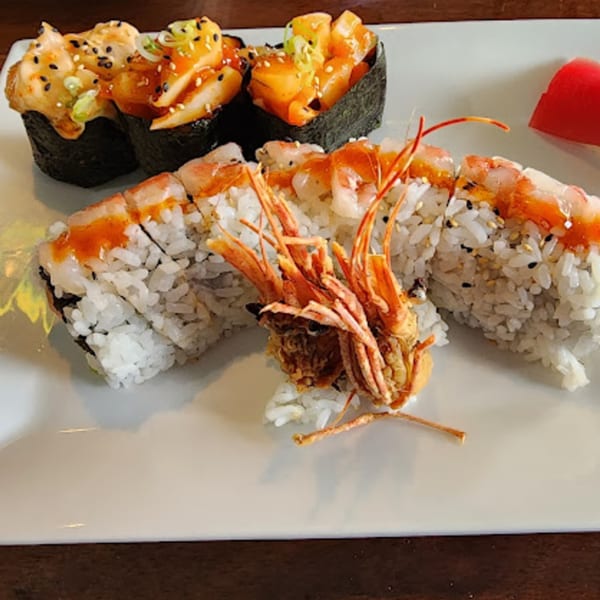 A plate of Siam Orchid Cocoa Beach sushi rolls, including shrimp tempura and gunkan maki.