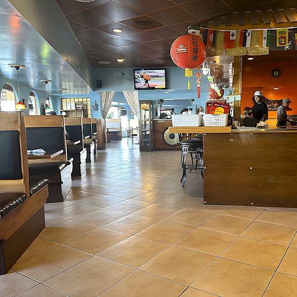 Interior of Siam Orchid Cocoa Beach, featuring booths, a counter, and Thai-inspired decor.